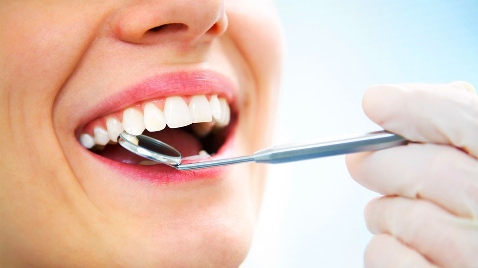 Dintii unei fete verificati de un dentist.